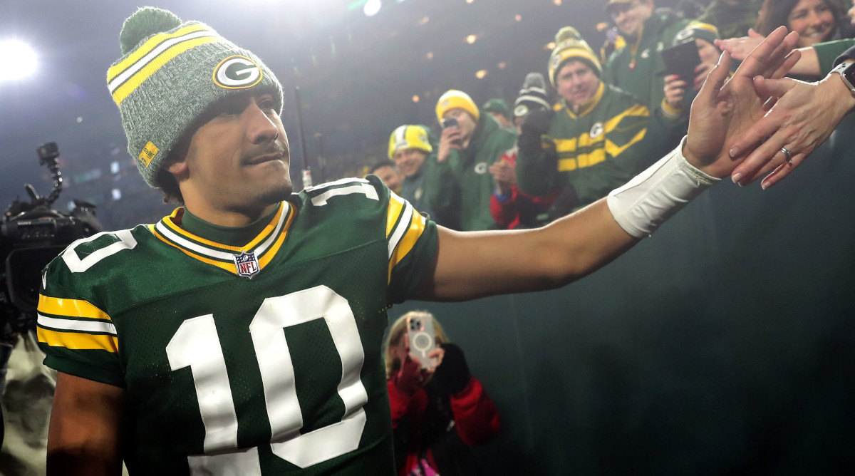 Jordan Love high fives fans in the stadium